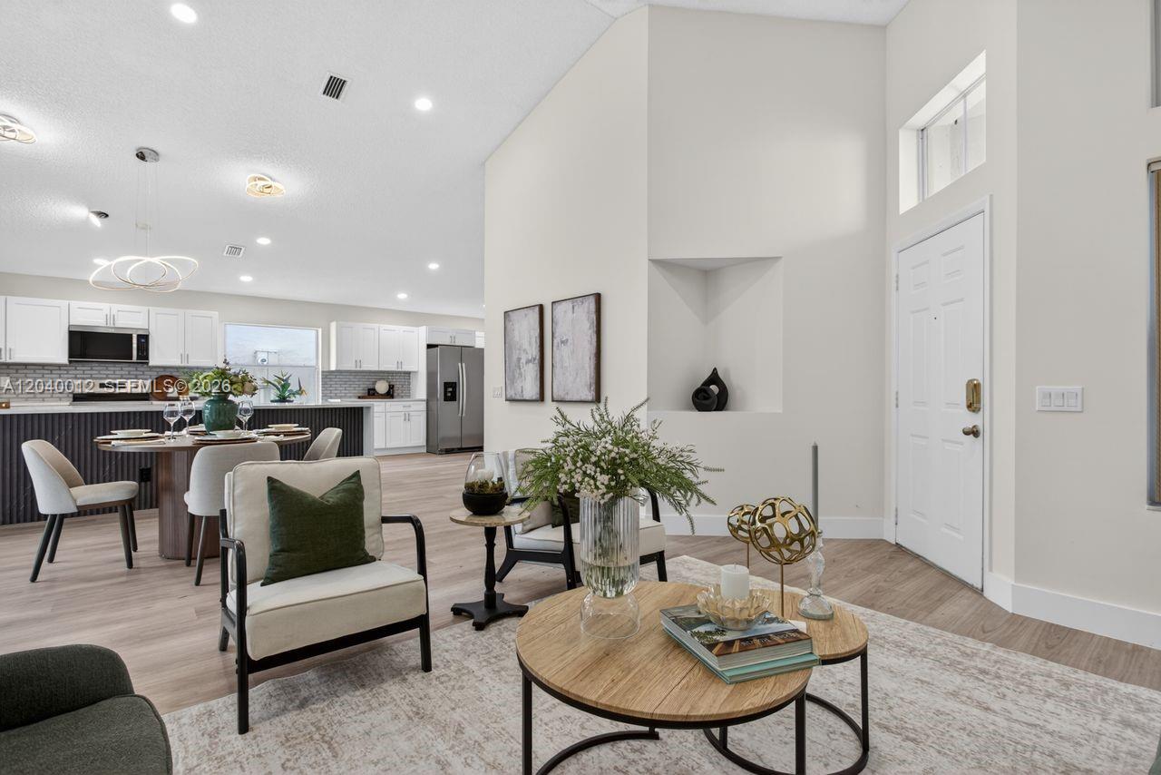 A bright, open-concept living area features a dining space, kitchen, and modern neutral decor — 116 W Bayridge Dr, Weston FL 33326, WESTON, FL