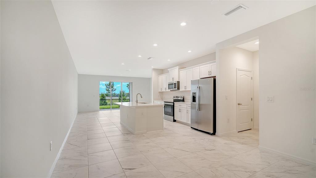 A modern kitchen with white cabinets, stainless steel appliances, and a central island — 2357 WASHINGTON PALM COURT, BRADENTON, FL