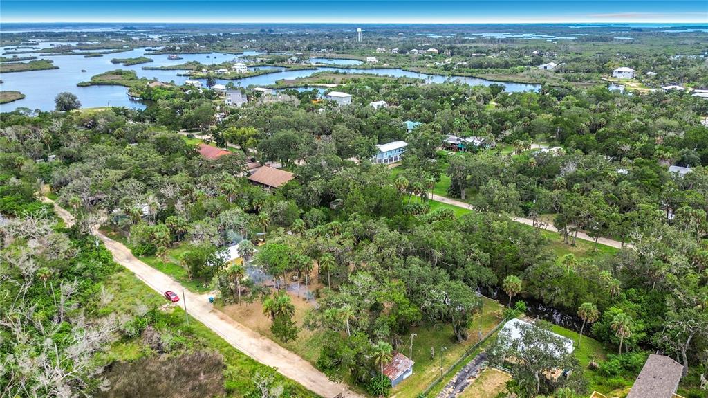 An aerial view shows a rural neighborhood with houses nestled among dense trees and waterways — 14334 W SUTTON COURT, CRYSTAL RIVER, FL