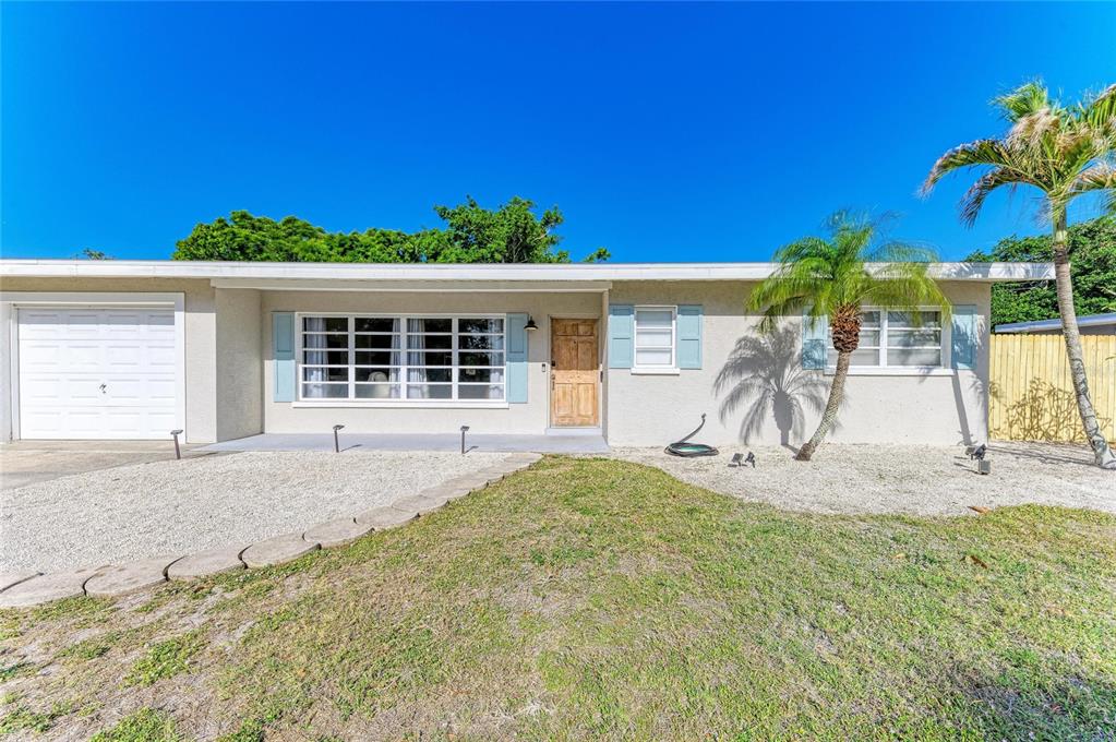 A living room features a white console table, a leather sofa, and a front door — 120 60TH STREET W, BRADENTON, FL