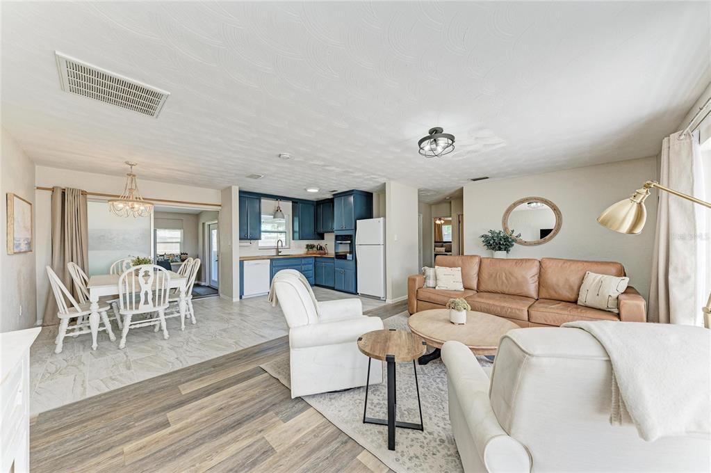 A kitchen features blue cabinets, wood countertops, a white refrigerator, and light-colored tile flooring — 120 60TH STREET W, BRADENTON, FL