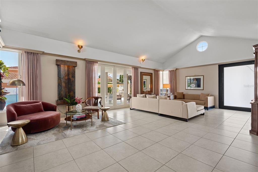 A spacious living room features vaulted ceilings, tile flooring, a water feature, and glass doors — 377 CORREDOR DE LA ARBOLEDA, DORADO, PR