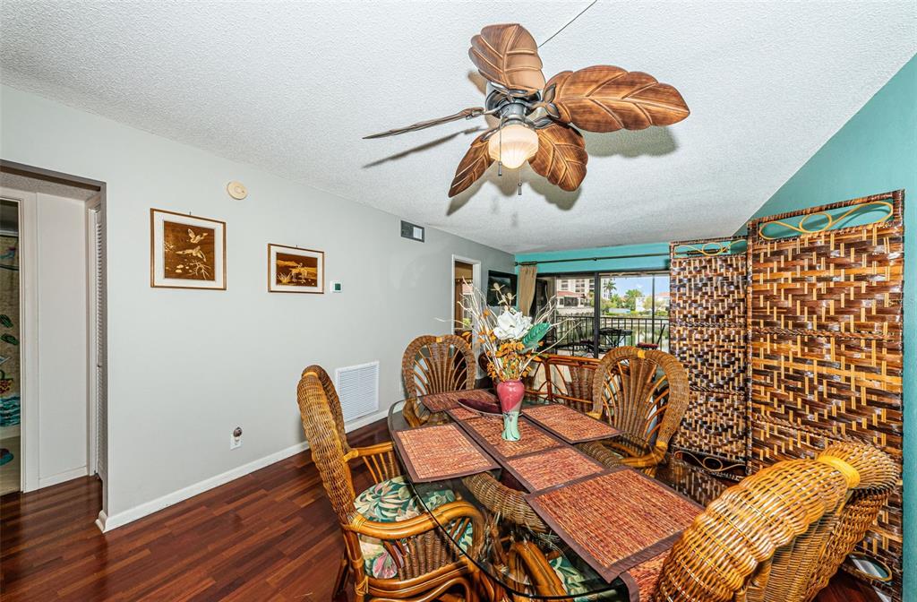 A dining room features a glass-top wicker table, tropical ceiling fan, and dark wood flooring — 6281 BAHIA DEL MAR BOULEVARD UNIT 208, ST PETERSBURG, FL
