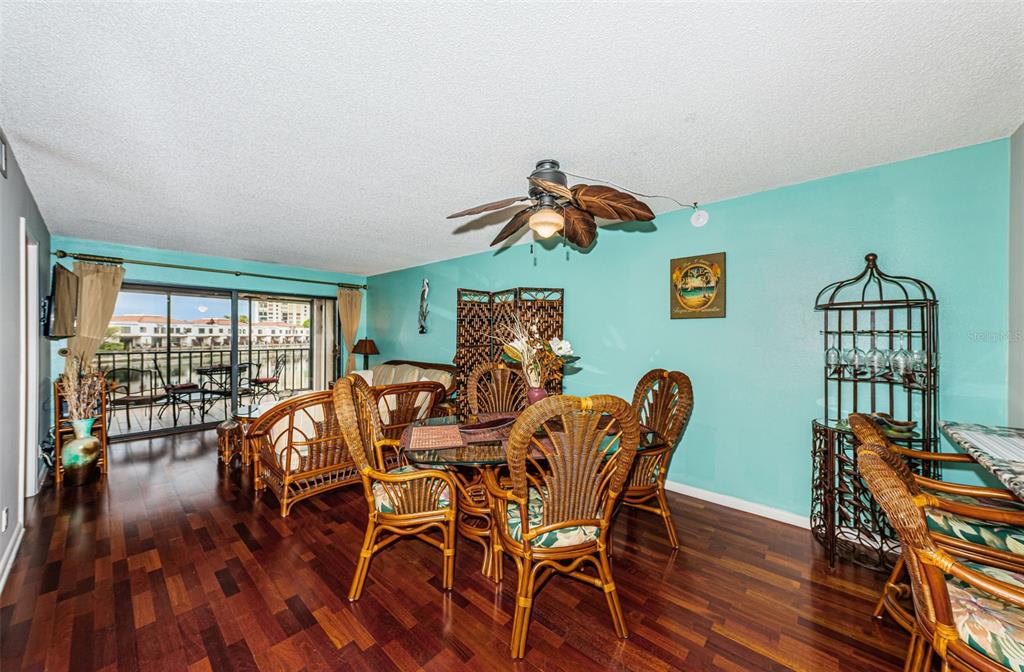 A dining area with wicker furniture, a glass table, and a balcony view of water — 6281 BAHIA DEL MAR BOULEVARD UNIT 208, ST PETERSBURG, FL