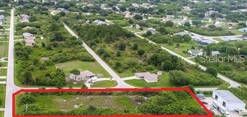 An aerial view shows a rectangular, undeveloped grassy lot outlined in red — 10043-10075 TRAMORE AVENUE, ENGLEWOOD, FL