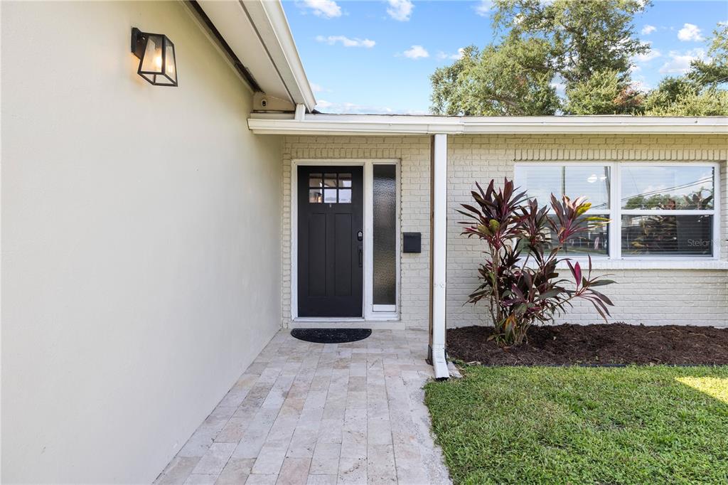 A front entrance features a black door, a side window, and a paved walkway — 6623 12TH TERRACE N, ST PETERSBURG, FL