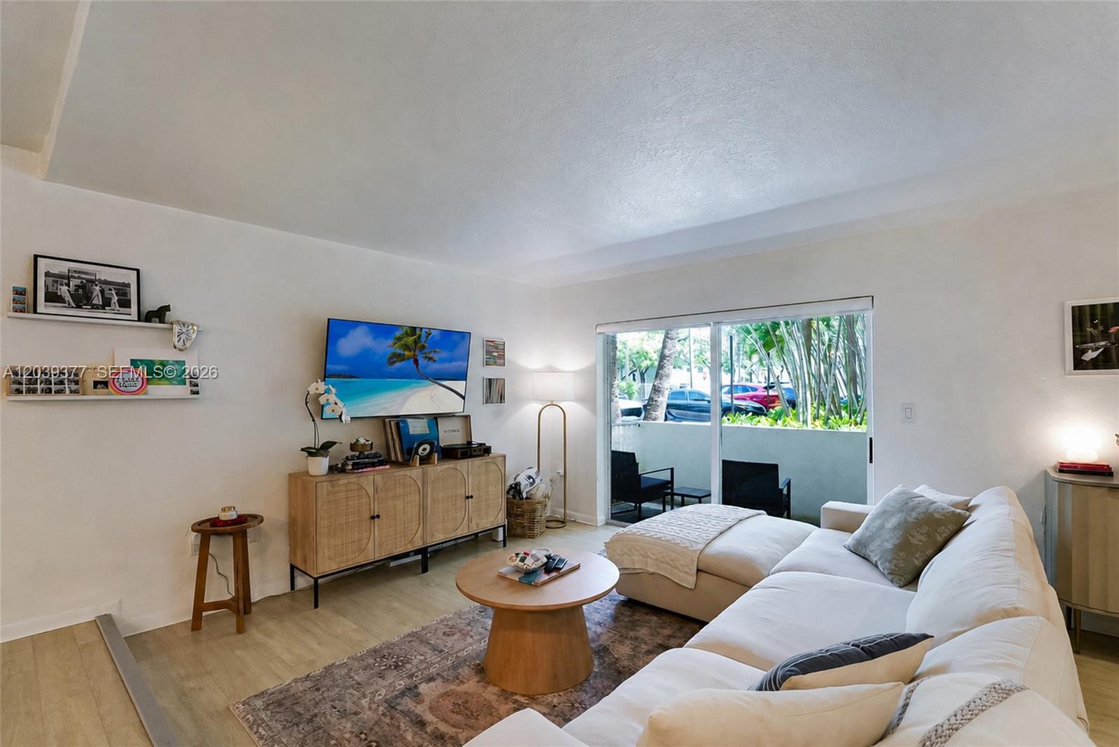 A living room features a white sofa, a wooden coffee table, and a media console — 8950 SW 69th Ct # 109, Pinecrest FL 33156, PINECREST, FL