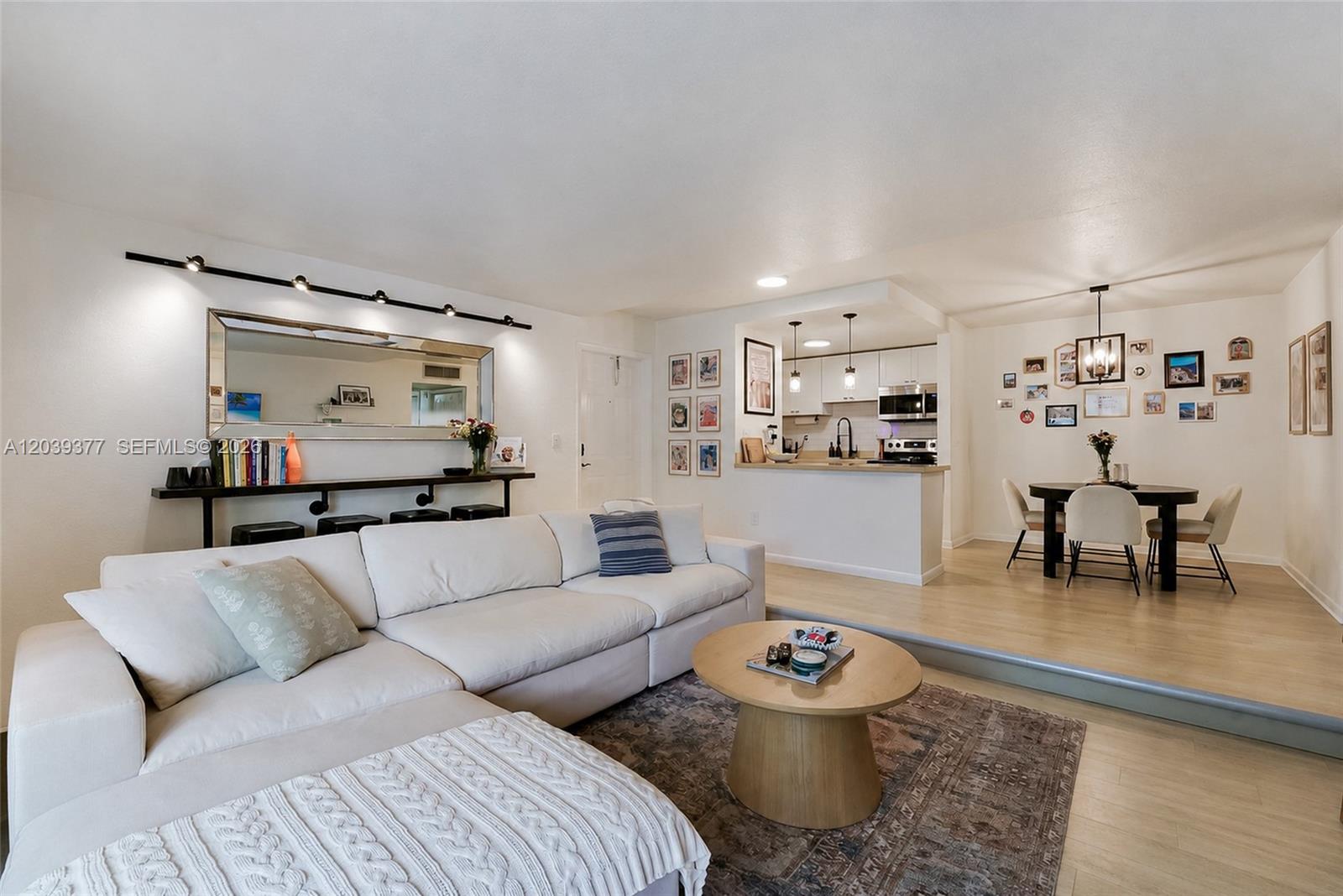 A living room with a white sectional sofa, a coffee table, and an adjacent dining area — 8950 SW 69th Ct # 109, Pinecrest FL 33156, PINECREST, FL