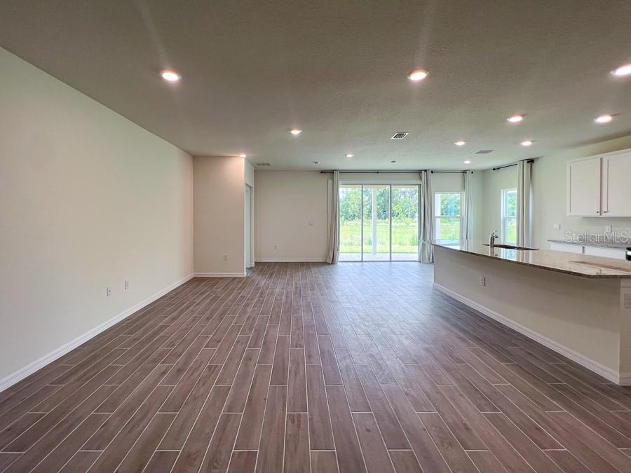 An open-concept living area features wood-look tile flooring, recessed lighting, and a kitchen island — 1315 NW 132ND CIRCLE, NEWBERRY, FL