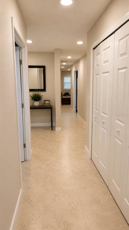 A hallway features light-colored tile flooring, recessed lighting, and white bi-fold closet doors — 150 W 11TH STREET, CHULUOTA, FL