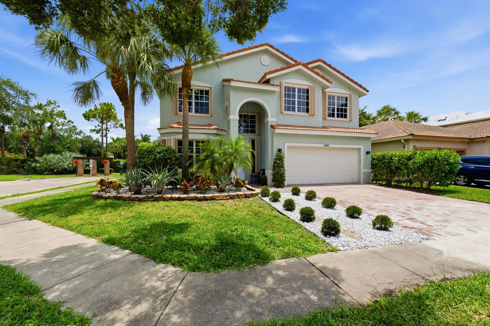 A two-story light green house with a tile roof, palm trees, and a paved driveway — 12197 Colony Preserve Drive, Boynton Beach FL 33436, BOYNTON BEACH, FL