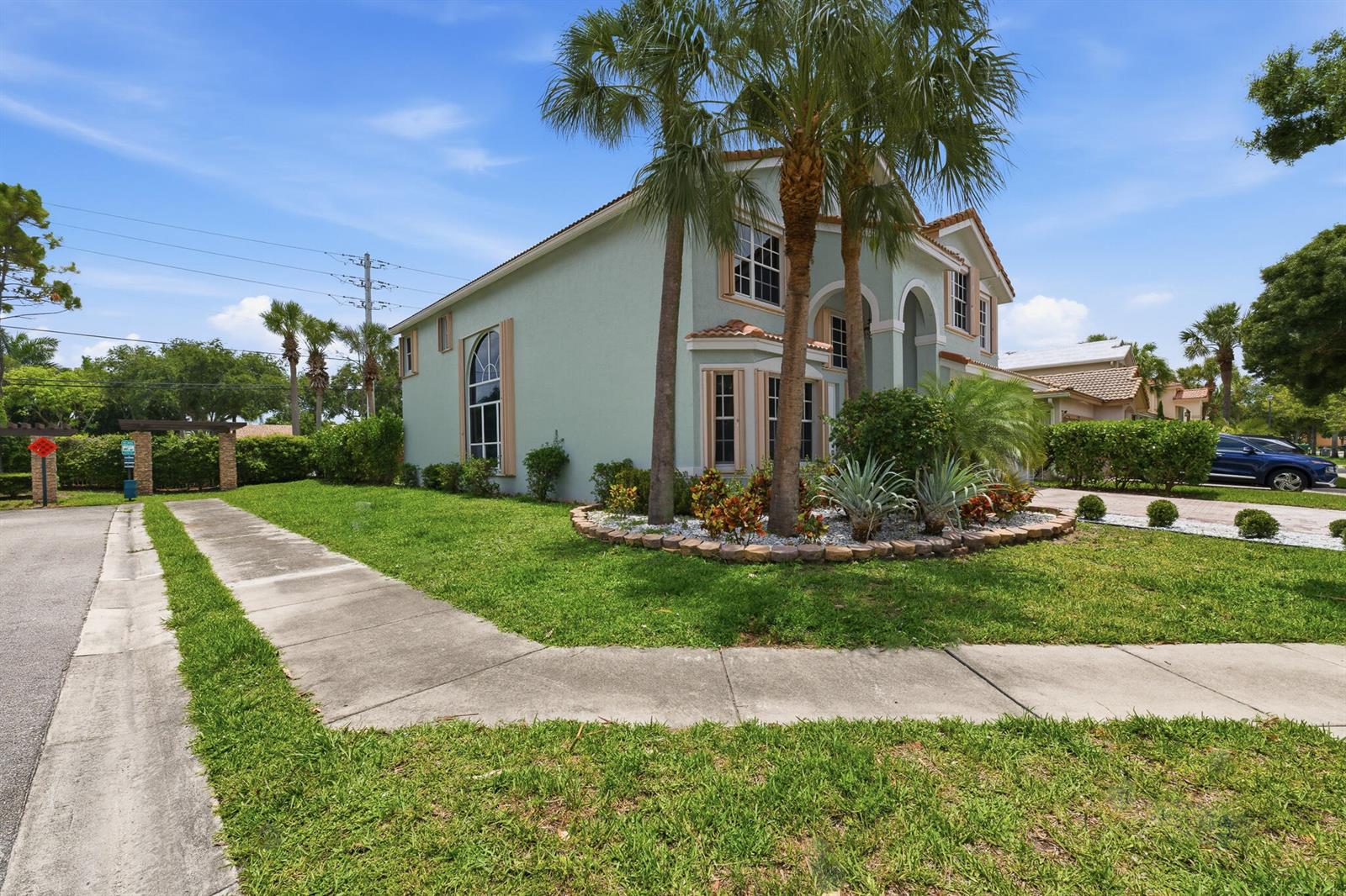 A two-story light green house with a palm tree-filled garden and a concrete driveway — 12197 Colony Preserve Drive, Boynton Beach FL 33436, BOYNTON BEACH, FL