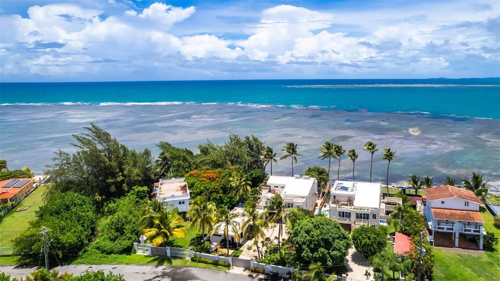 An aerial view shows several houses situated along a coastline with a shallow reef — Lot G Km 2.1 Carr. 968 LAS PICUAS, RIO GRANDE, PR