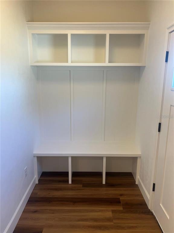 A white built-in mudroom bench with upper cubbies sits against a wall with wood flooring — 7848 SE 70TH AVENUE, TRENTON, FL