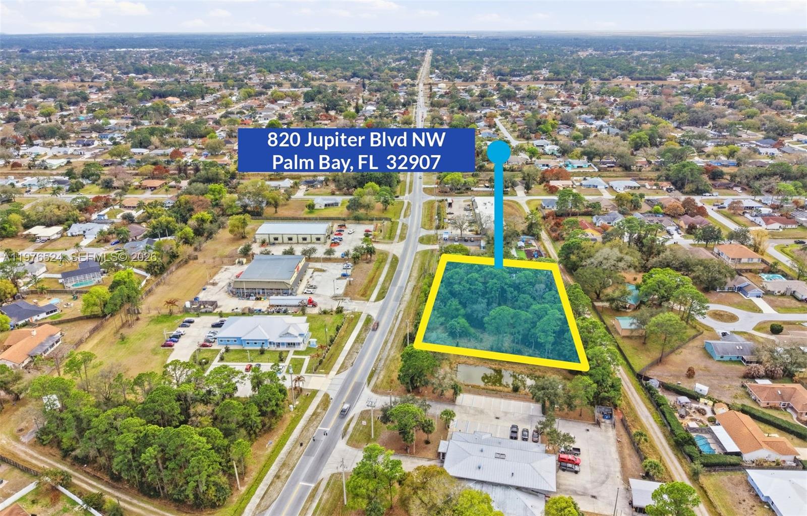 An aerial view shows a vacant, wooded lot highlighted in yellow next to a road — 820 Jupiter Blvd NW, Palm Bay FL 32907, PALM BAY, FL