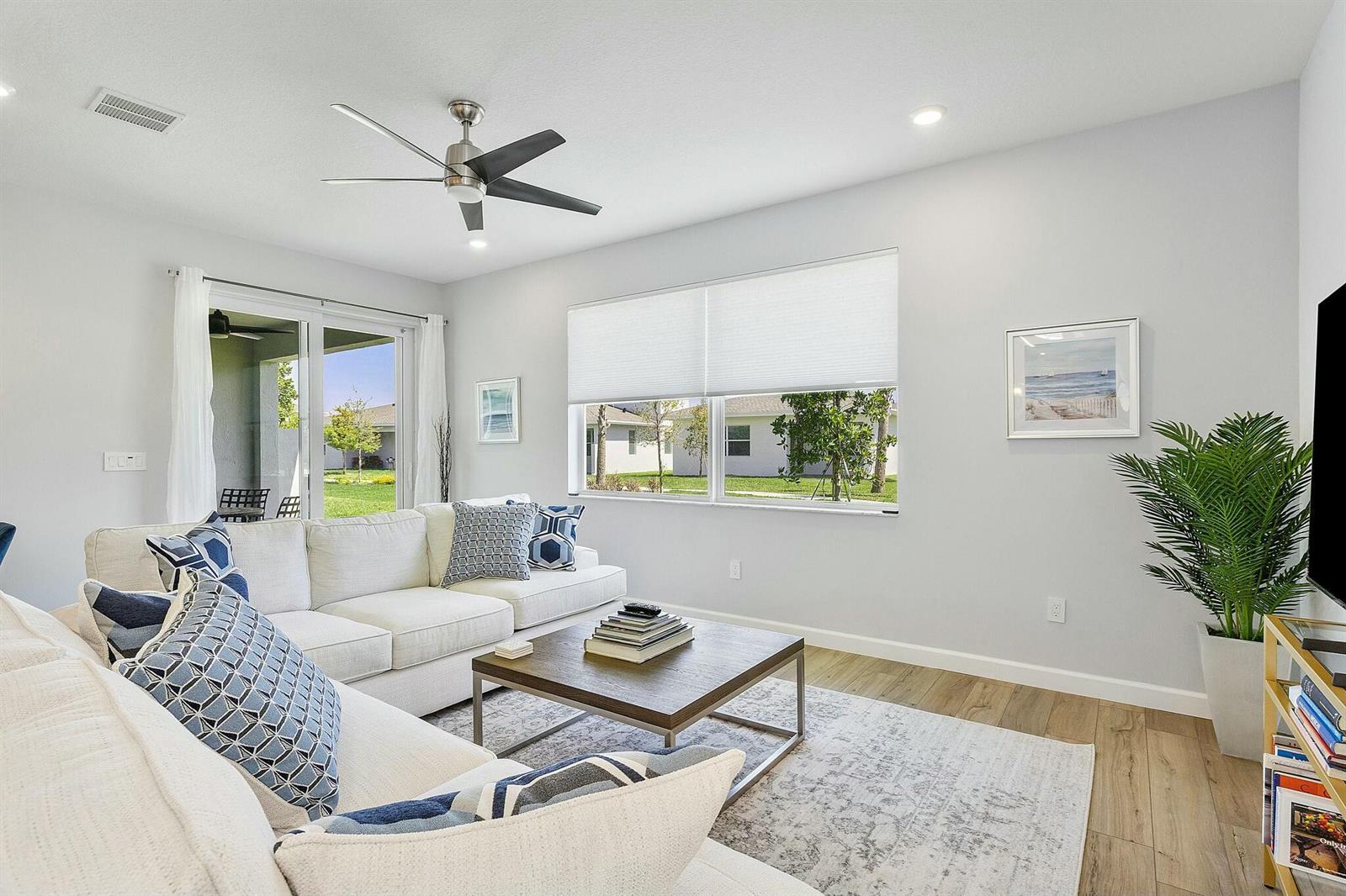A living room features a white sectional sofa, a wooden coffee table, and large windows — 13404 Brotherhood Way, Delray Beach FL 33484, DELRAY BEACH, FL