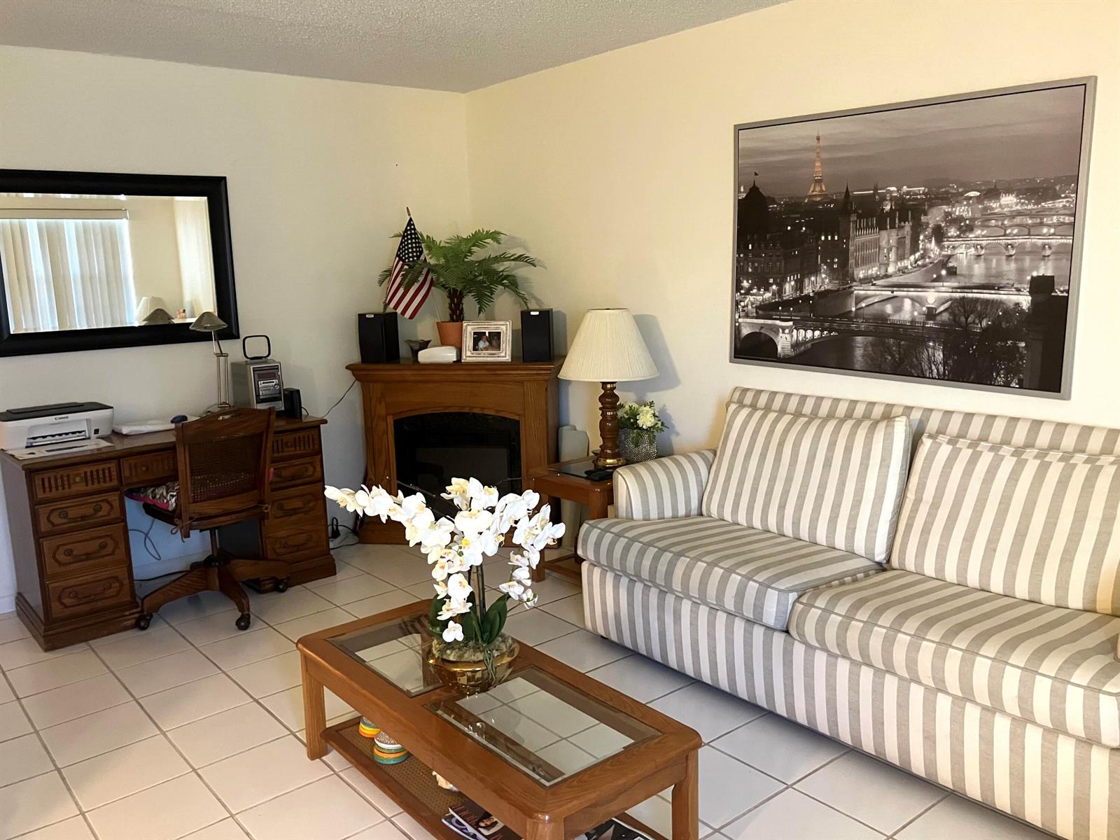A living room features a striped sofa, a wooden desk, a fireplace, and tile flooring — 283 Durham H E # 283, Deerfield Beach FL 33442, DEERFIELD BEACH, FL