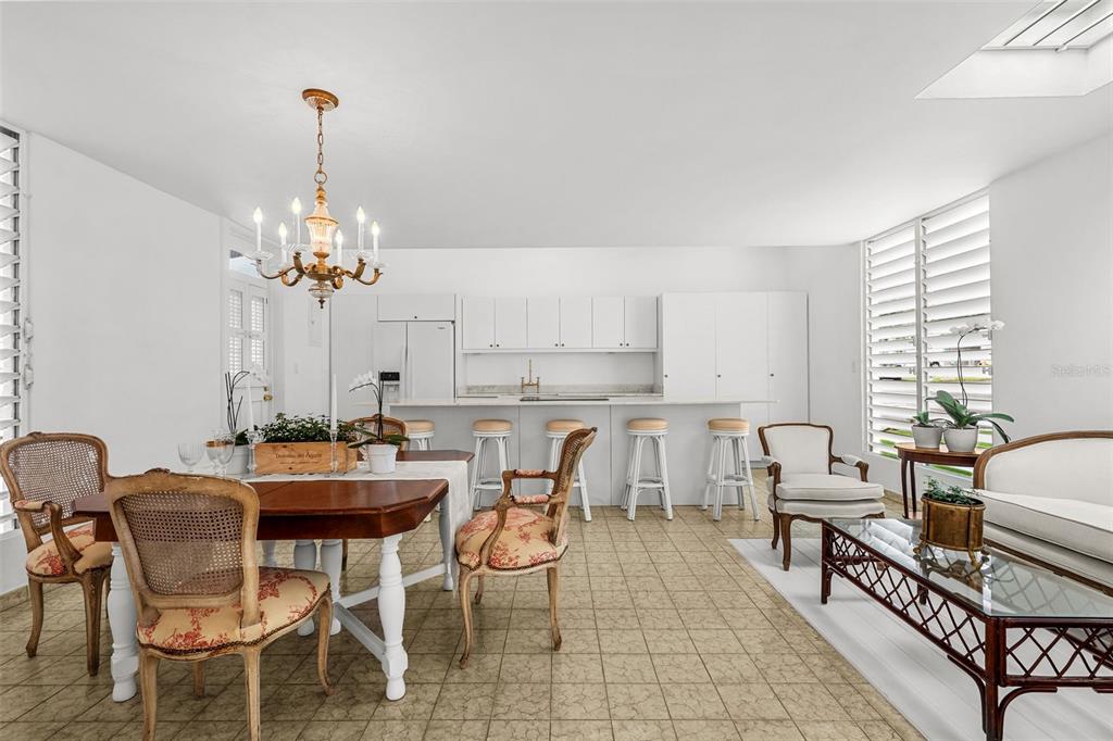 A dining and living area features a kitchen island, tile flooring, and a chandelier — AF7 Villa Franca BARCELONA ST, HUMACAO, PR