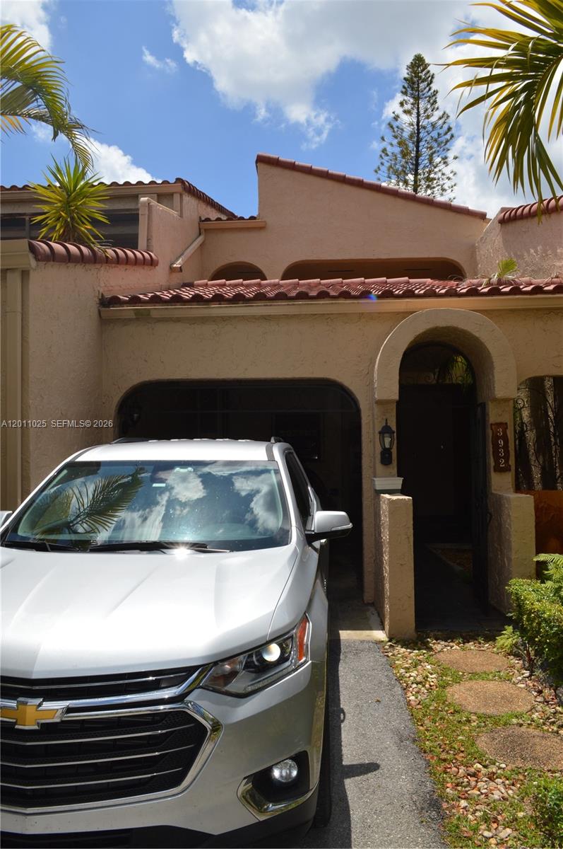 A silver SUV is parked in the driveway of a tan stucco house — 3932 Estepona Ave, Doral FL 33178, DORAL, FL