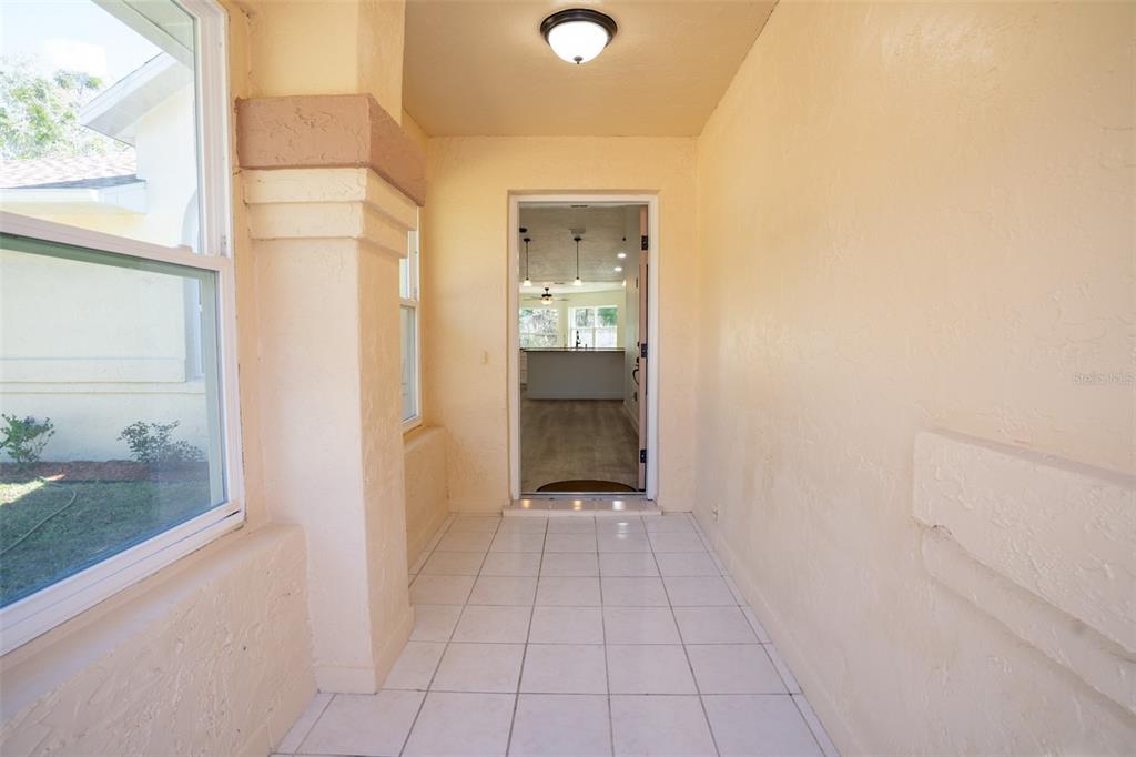 A covered entryway with tiled flooring leads into the interior of a house — 12989 NW HIGHWAY 225, REDDICK, FL