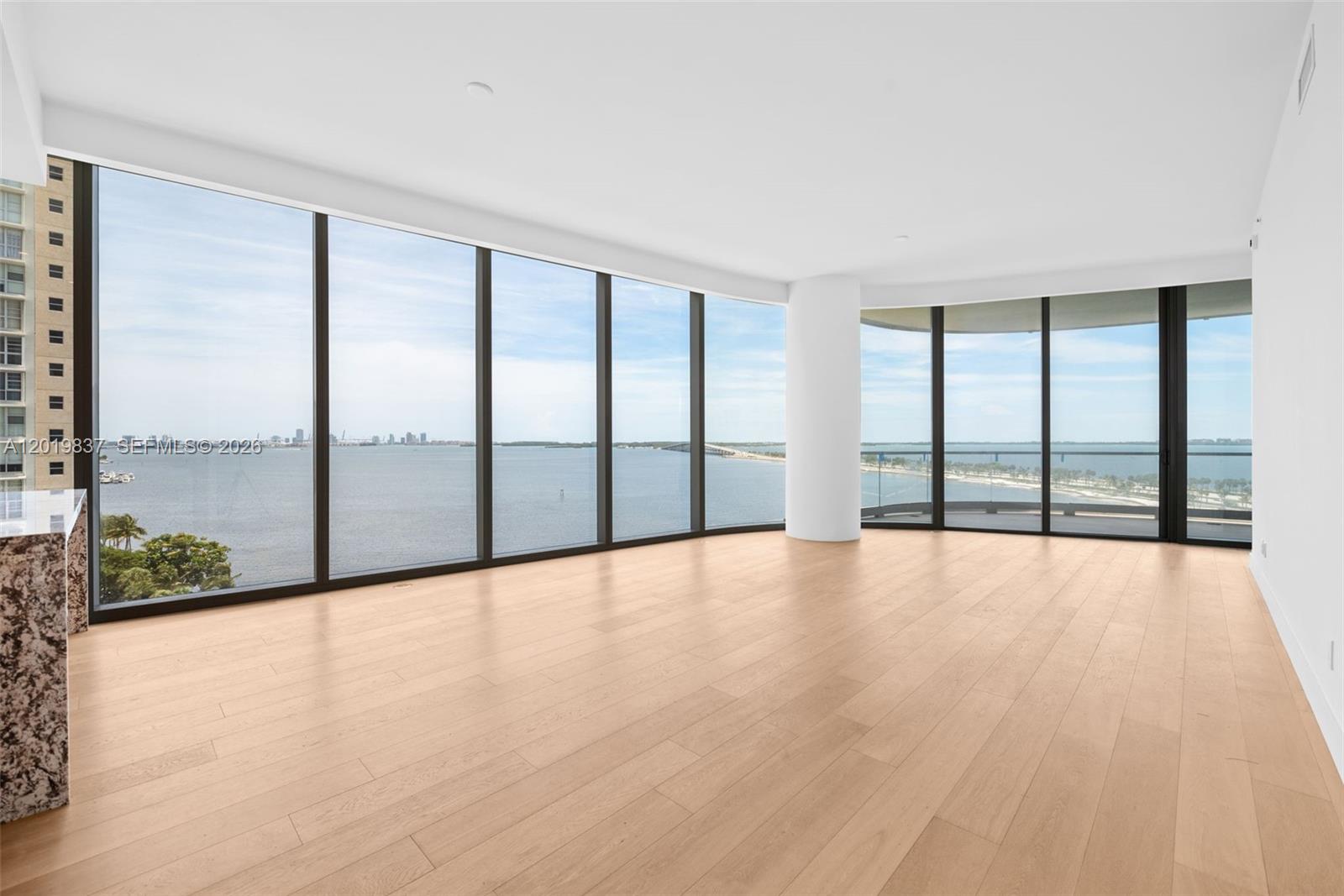 An empty room features light wood flooring, white walls, and floor-to-ceiling windows overlooking water — 175 SE 25 Rd # 801, Miami FL 33129, MIAMI, FL
