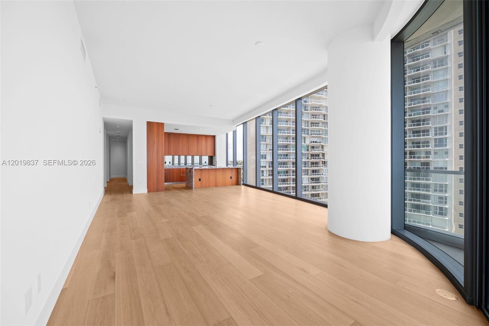 An open-concept living area features light wood flooring, floor-to-ceiling windows, and a modern kitchen — 175 SE 25 Rd # 801, Miami FL 33129, MIAMI, FL