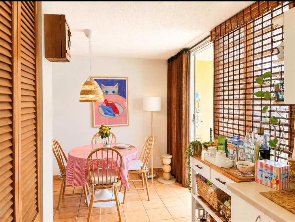 A dining area features a round table with a red-striped cloth, wooden chairs, and artwork — PRINCIPAL CASA DEL MAR II UNIT 2705, RIO GRANDE, PR