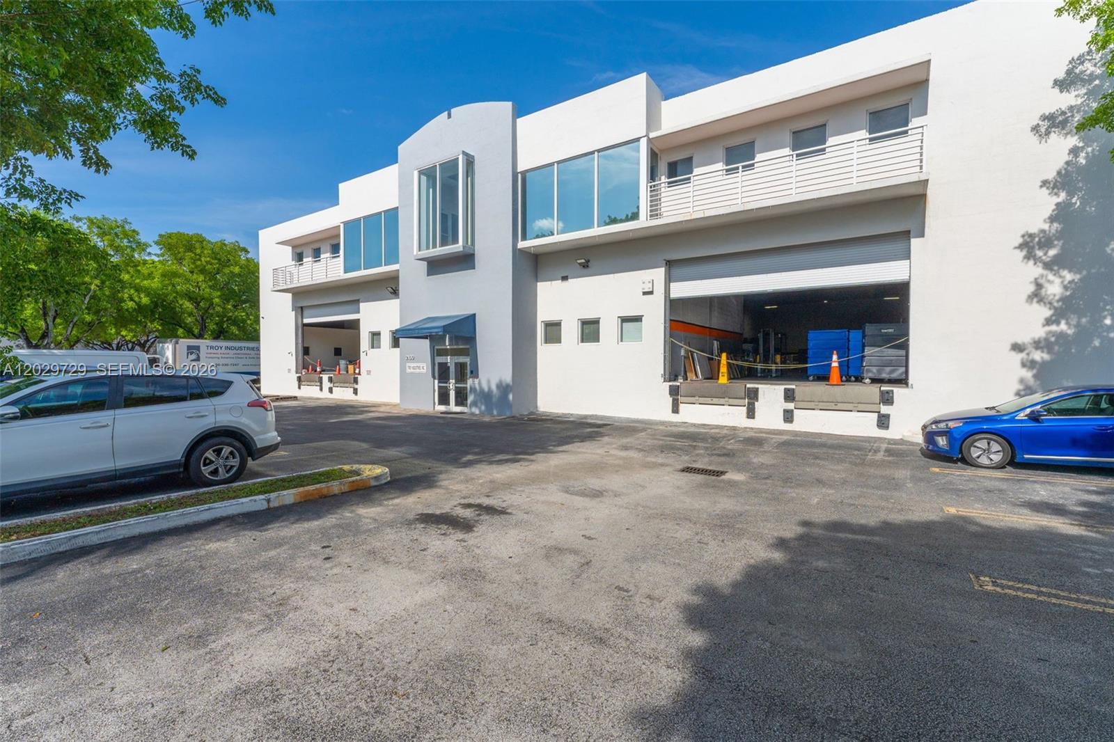 A two-story commercial building with loading docks and a paved parking lot in front — 2100 NW 102nd Pl, Doral FL 33172, DORAL, FL
