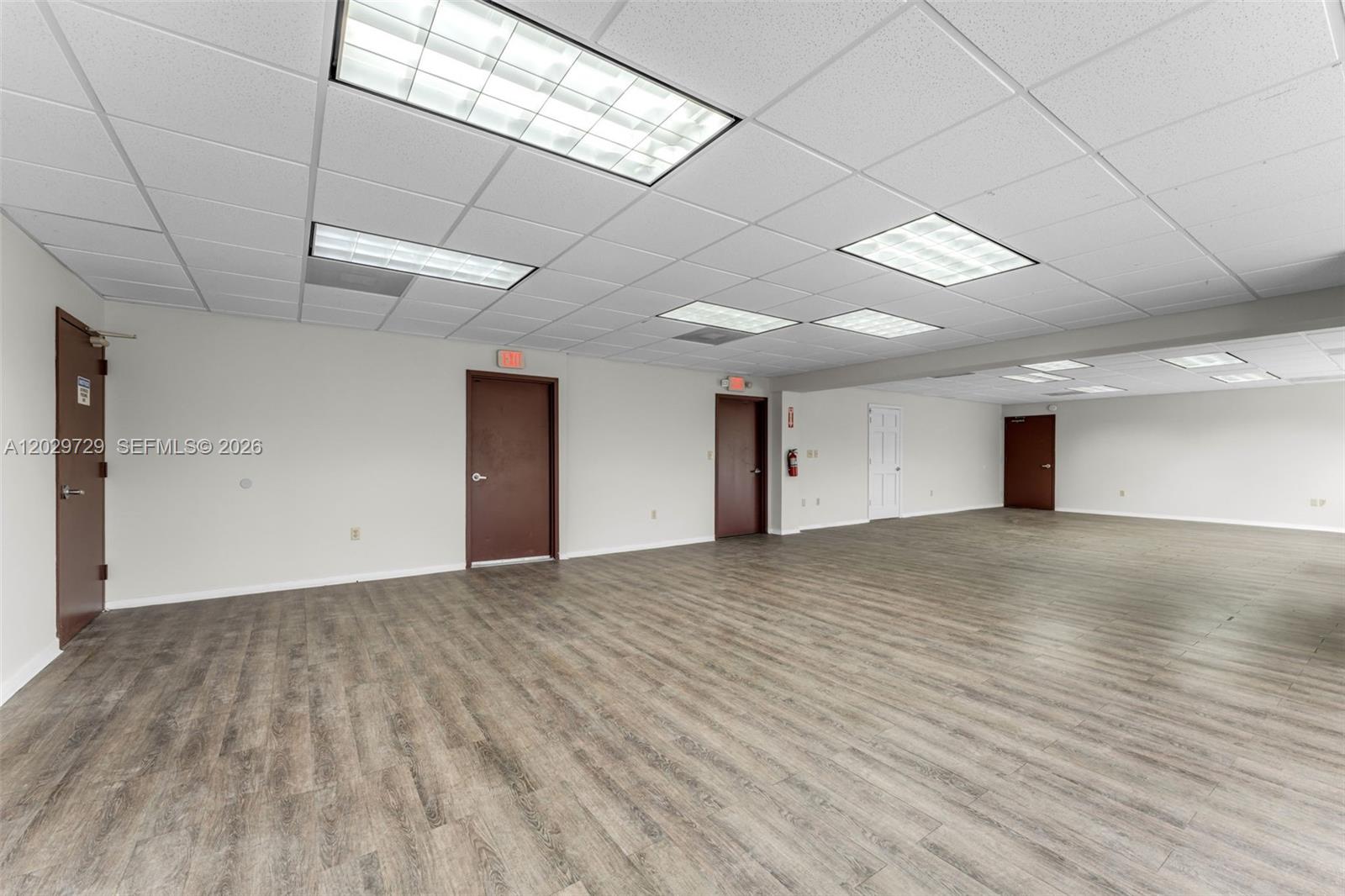 An empty office space features light gray walls, wood-look flooring, and a drop ceiling — 2100 NW 102nd Pl, Doral FL 33172, DORAL, FL