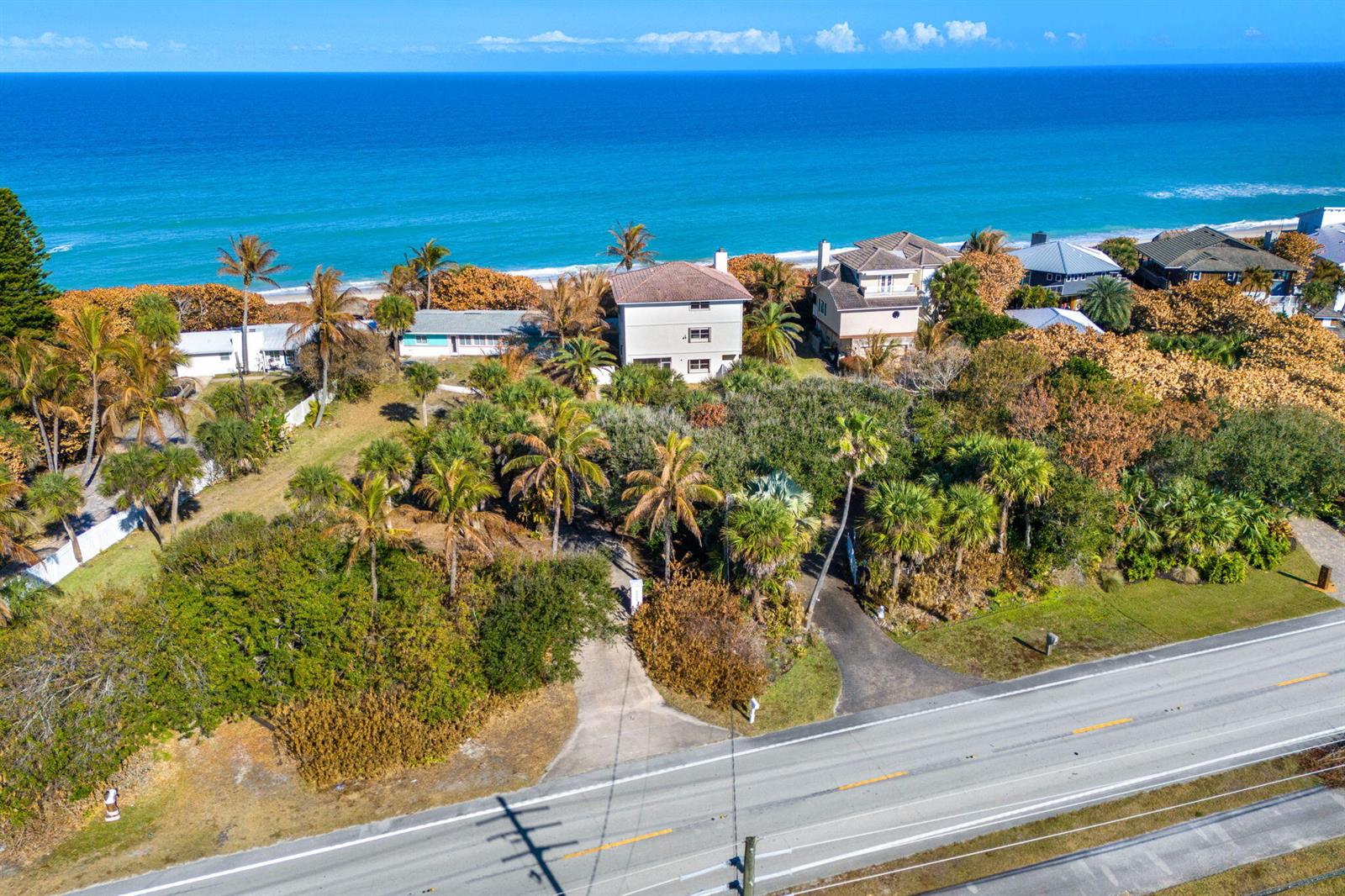An aerial view shows coastal homes surrounded by palm trees near a road and ocean — 9085 S Highway A1a, Melbourne Beach FL 32951, MELBOURNE BEACH, FL