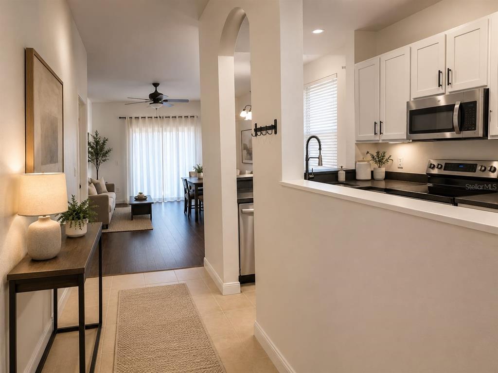 A view from a tiled hallway into a kitchen and a living area with wood floors — 2761 RETREAT VIEW CIRCLE, SANFORD, FL