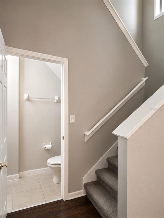 A view of a staircase with gray carpet next to a small bathroom with tile — 2761 RETREAT VIEW CIRCLE, SANFORD, FL