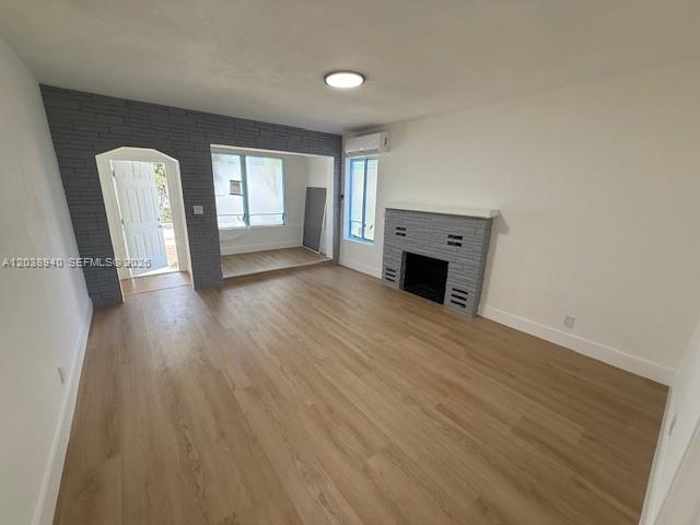 A living room features light wood flooring, a gray brick fireplace, and a white door — 1123 N 17th Ct, Hollywood FL 33020, HOLLYWOOD, FL