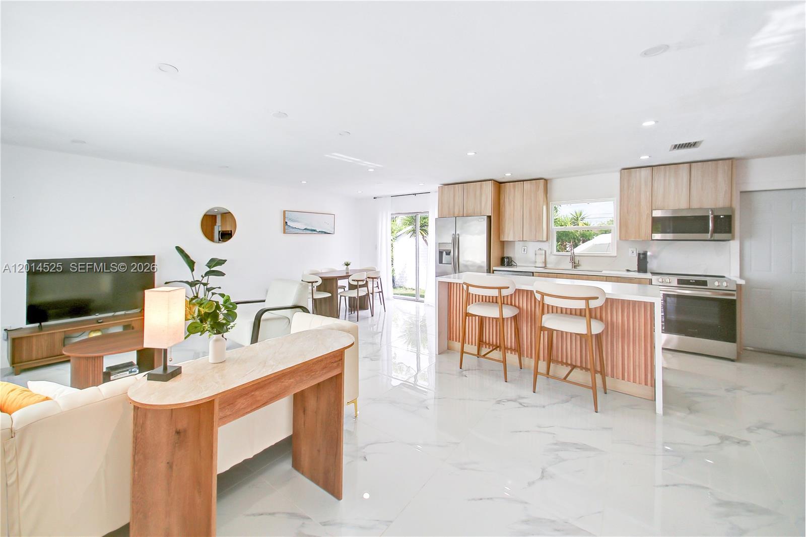 An open-concept kitchen and living area features white marble-style flooring and light wood cabinetry — 22114 SW 113th Pl, Miami FL 33170, MIAMI, FL
