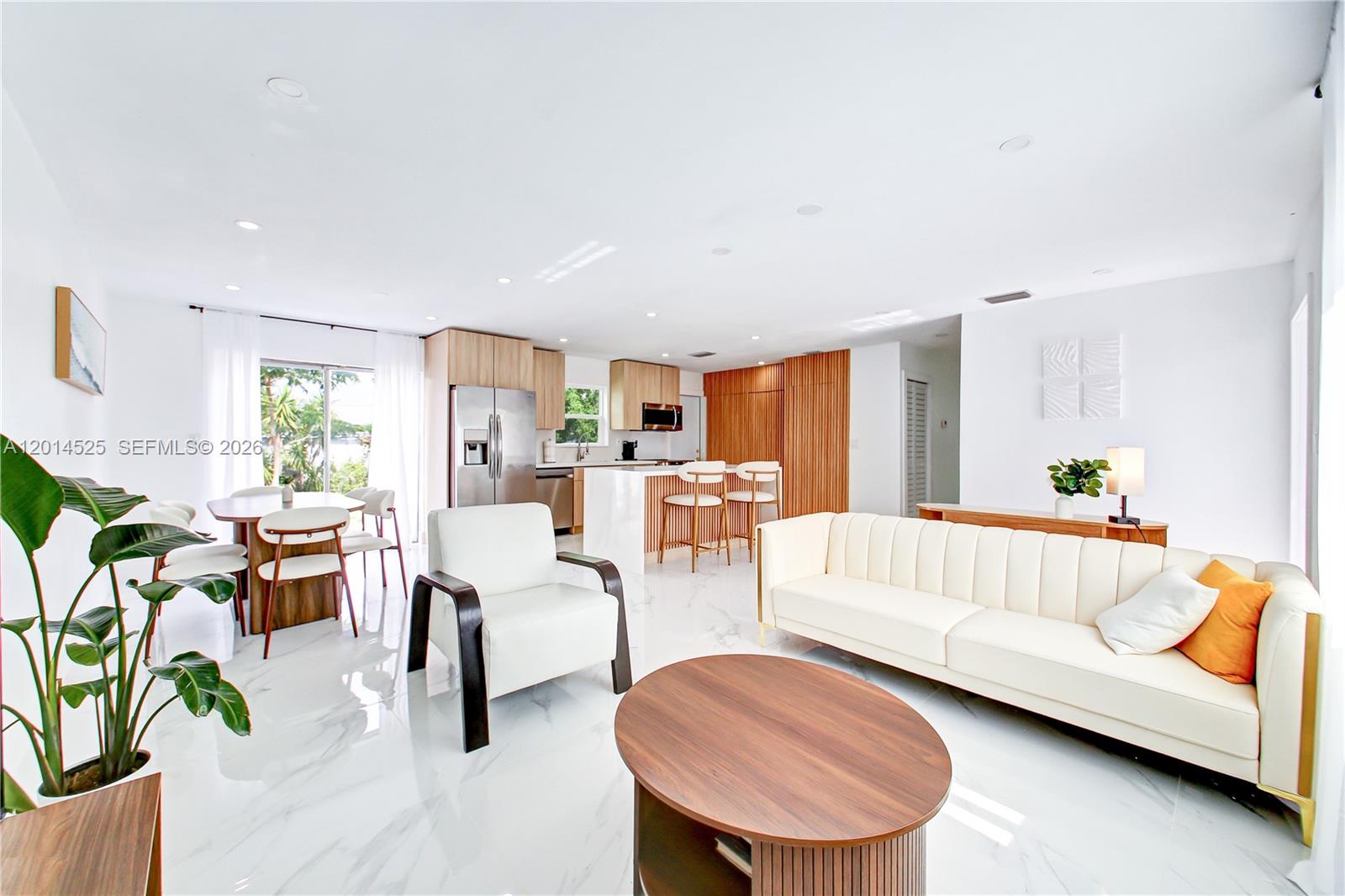 An open-concept living and dining area features white marble floors, modern furniture, and wood cabinetry — 22114 SW 113th Pl, Miami FL 33170, MIAMI, FL