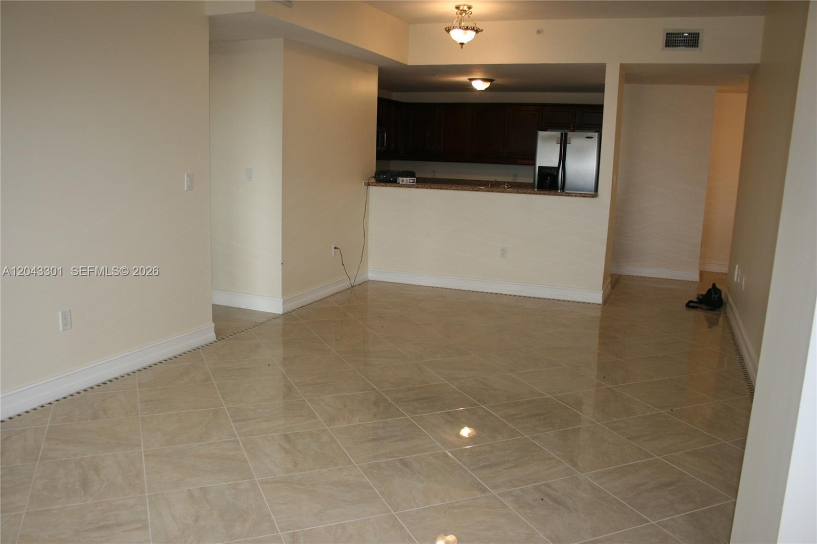 A beige bathtub is set against tan tiled walls with a built-in shelf — 5271 SW 8th St # 216, Miami FL 33134, MIAMI, FL
