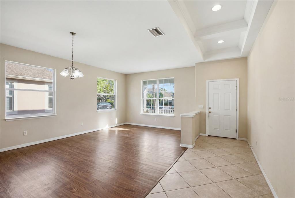 A room with wood-look flooring, tile entry, a chandelier, and a white front door — 12512 23RD STREET E, PARRISH, FL
