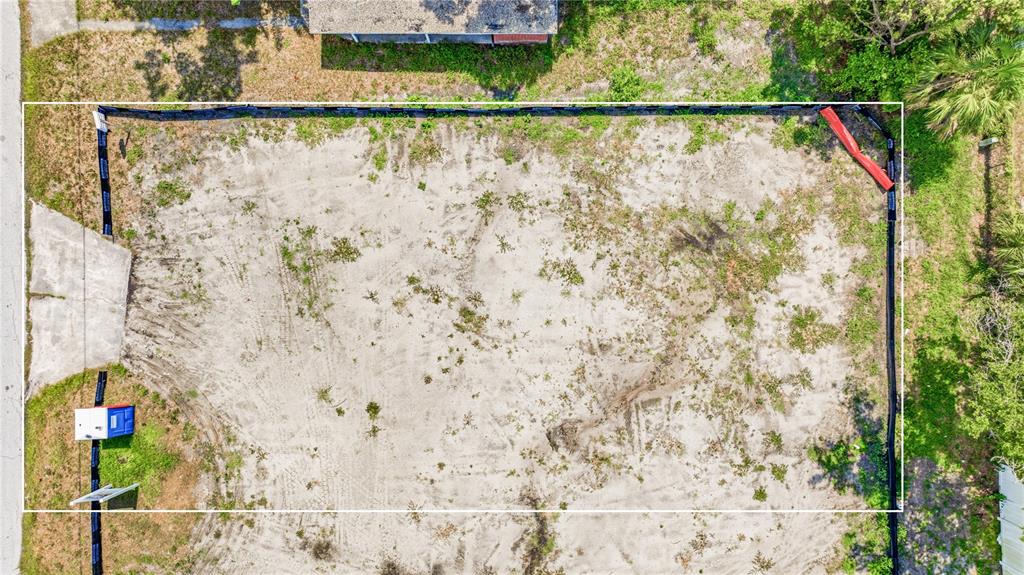 An aerial view of a vacant, sandy residential lot enclosed by black silt fencing — 1710 W SAINT CONRAD STREET, TAMPA, FL