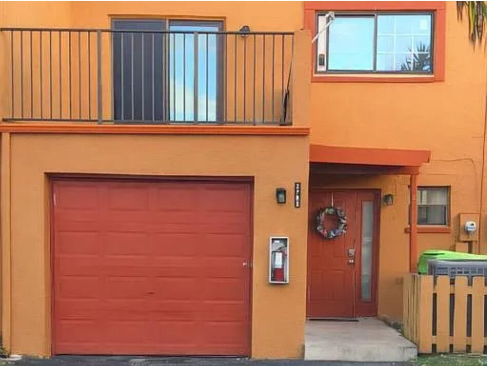 An orange two-story townhouse features a red garage door, a front door, and a balcony — 2790 NW 80th Avenue, Sunrise FL 33322, SUNRISE, FL