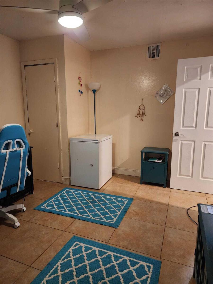 A room with tile flooring, a chest freezer, a blue nightstand, and two blue rugs — 2790 NW 80th Avenue, Sunrise FL 33322, SUNRISE, FL