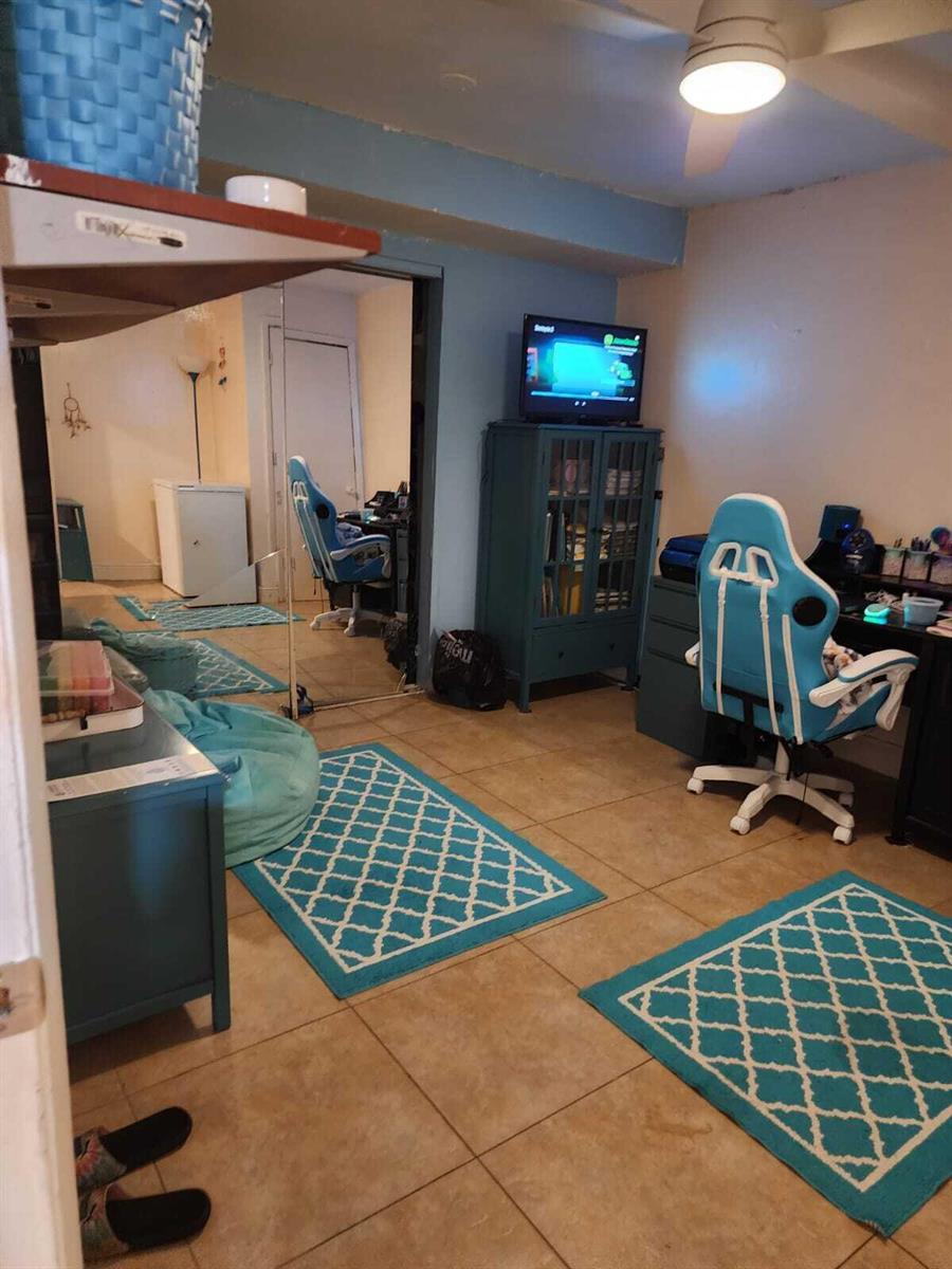 A room with tile flooring, a blue gaming chair, a television, and area rugs — 2790 NW 80th Avenue, Sunrise FL 33322, SUNRISE, FL