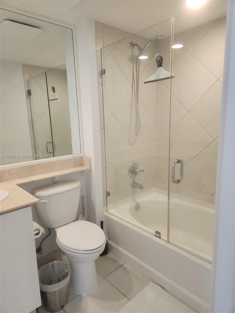 A bathroom features a toilet, a vanity, and a shower-tub combination with glass doors — 325 S Biscayne Blvd # 1420, Miami FL 33131, MIAMI, FL