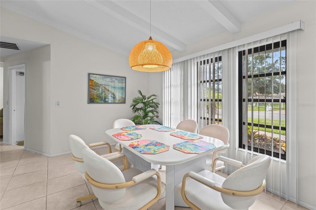 A dining room features a white table, six chairs, and a woven pendant light fixture — 4308 PASADENA CIRCLE, SARASOTA, FL