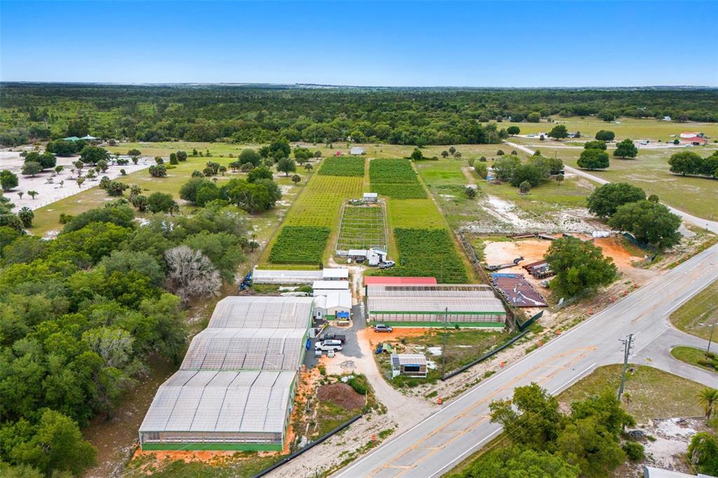 An aerial view shows a rural property with greenhouses, agricultural fields, and a paved road — 3510 WALK IN WATER ROAD, LAKE WALES, FL