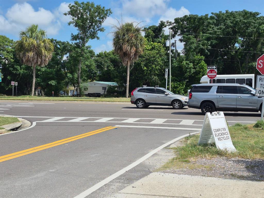 A street intersection features a white sandwich board sign advertising computer electronics recycling — 4007 FLAMINGO DRIVE, NEW PORT RICHEY, FL