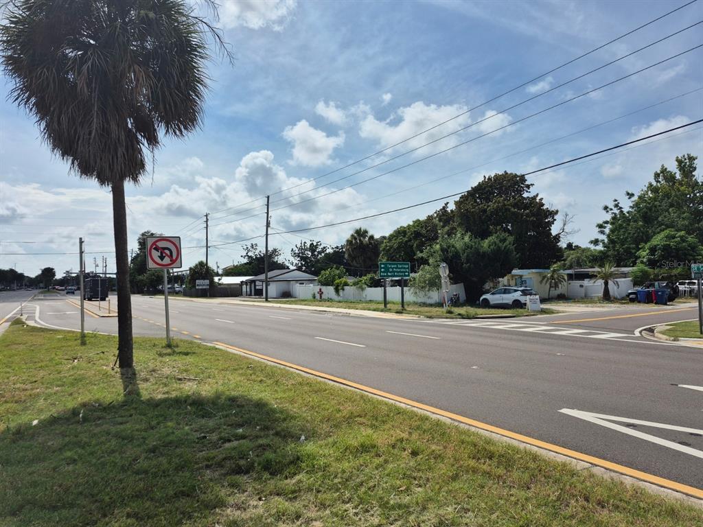 A view of a paved road intersection with a palm tree and directional road signs — 4007 FLAMINGO DRIVE, NEW PORT RICHEY, FL