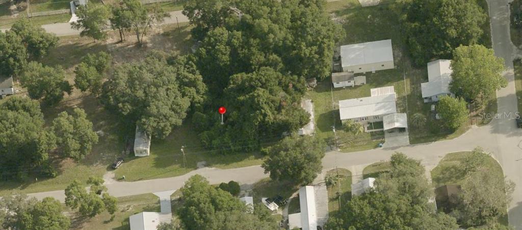An aerial view shows a wooded residential lot marked with a red pin — 0 SE 143 LN, SUMMERFIELD, FL