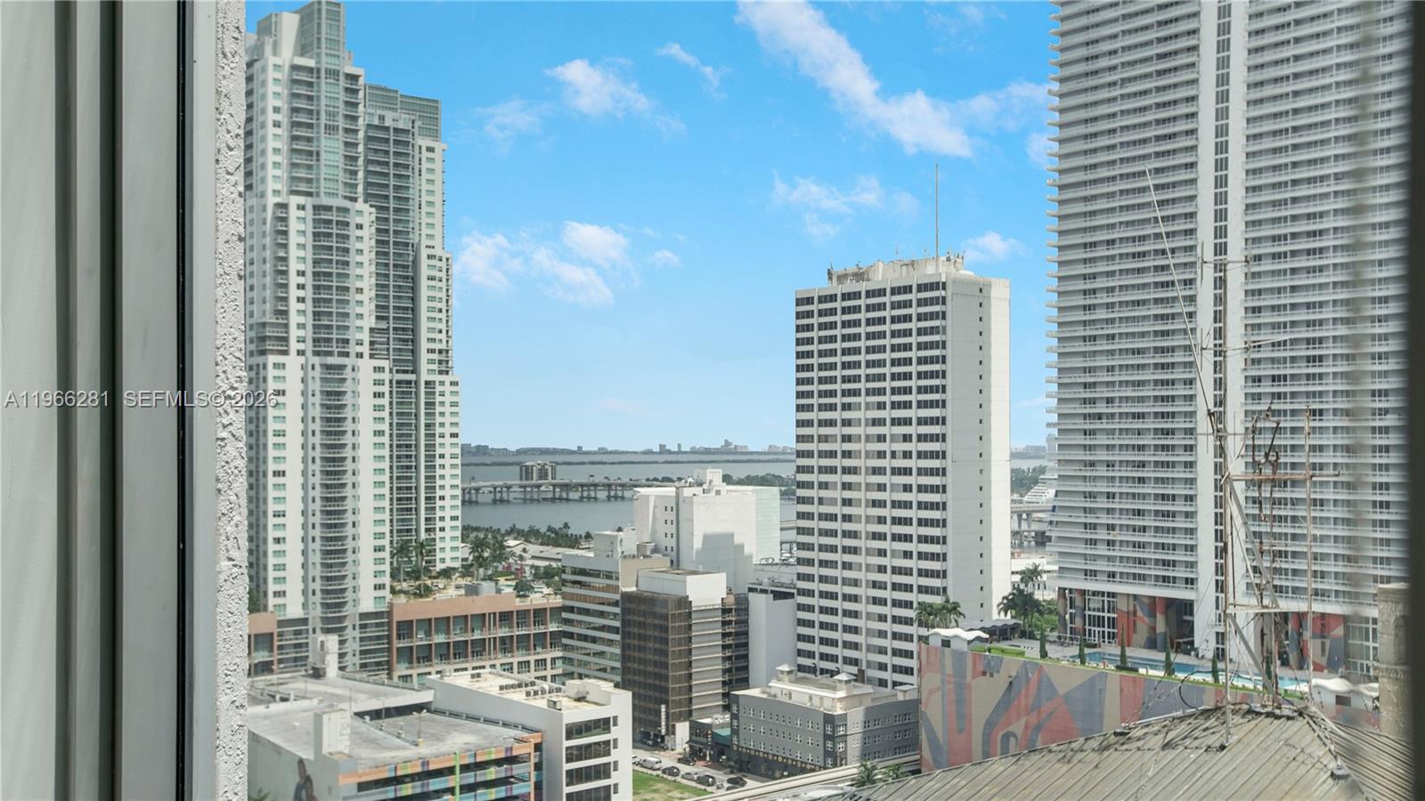 A high-angle view of a city skyline featuring several tall skyscrapers and a distant bridge — 151 SE 1st St # 2101, Miami FL 33131, MIAMI, FL