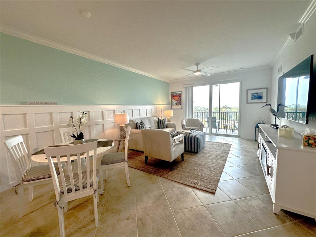 A living and dining area with light blue walls, white wainscoting, and tile flooring — 14041 HERITAGE LANDING BOULEVARD UNIT 634, PUNTA GORDA, FL