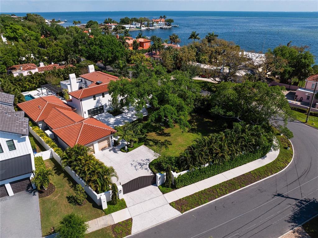 An aerial view shows a white house with a red tile roof and a gated driveway — 416 BRIGHTWATERS BOULEVARD NE, ST PETERSBURG, FL